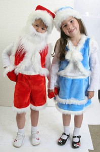 Девочка и мальчик в костюмах Деда Мороза и Снегурочки