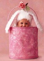 Маленькая девочка с длинными заячьими ушками в розовой коробке